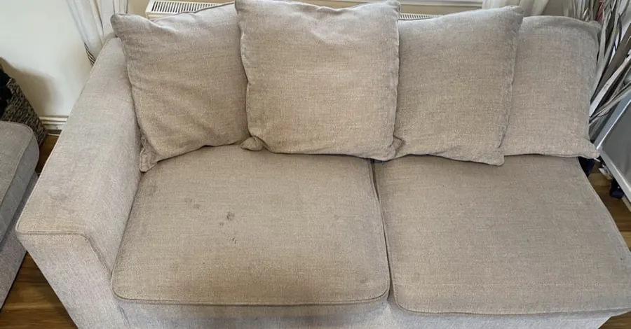 Gray sofa before cleaning, with stains on seat cushions